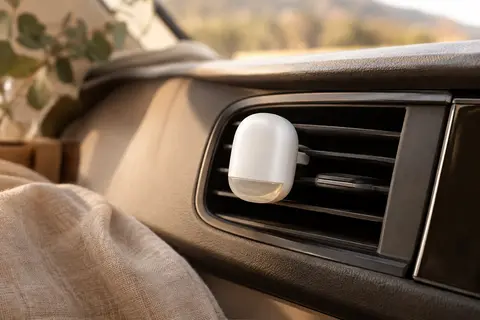 Diffuseur Areon blanc à clip fixé sur une grille d’aération dans l’habitacle d’une voiture