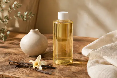 Recharge liquide parfumée à la vanille présentée sur du bois patiné dans une ambiance douce et naturelle.